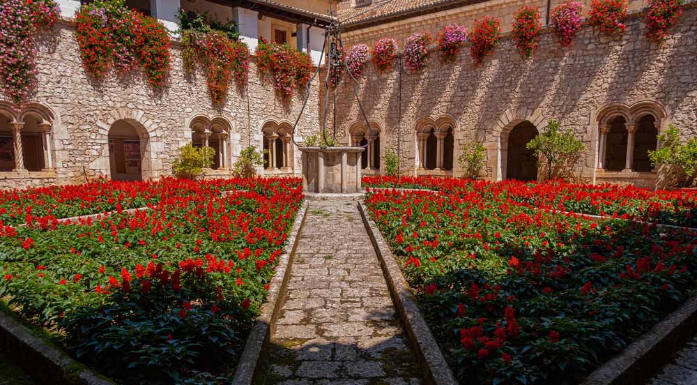 Immagine del chiostro dell'Abbazia di Casamari a Veroli, ricco di fiori