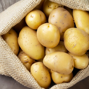 Sacco di patate su tavolo rustico - Foto di Uuganbayar da Adobe Stock