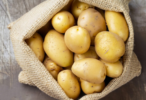 Sacco di patate su tavolo rustico - Foto di Uuganbayar da Adobe Stock