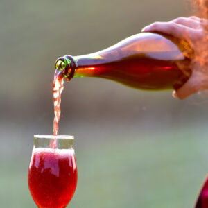 Ragazza versa vino rosso in un calice - Foto di barbamauro da Adobe Stock