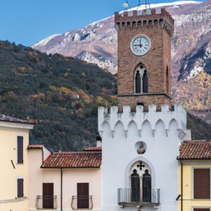 Scorcio della piazza principale del borgo, con il campanile e le montagne sullo sfondo