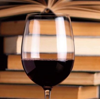 Calice di vino rosso e libri