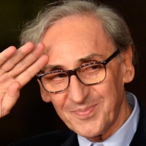 Primo piano di Franco Battiato mentre saluta "militarmente"