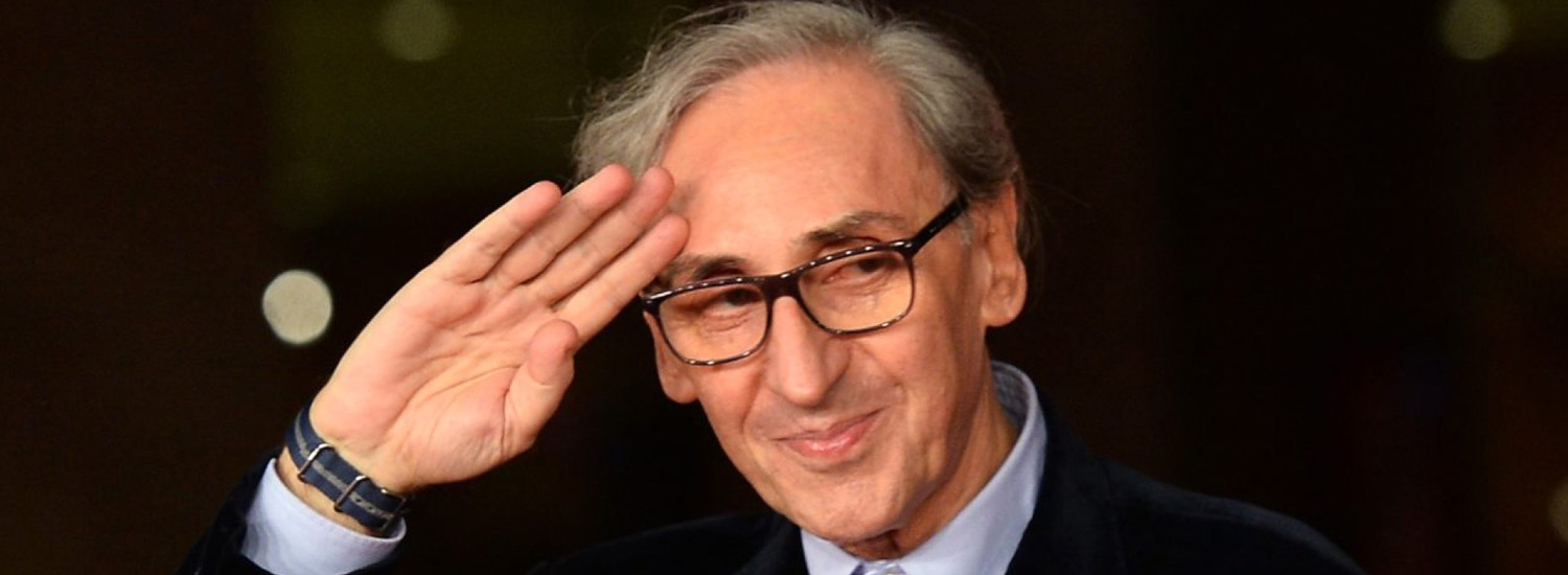 Primo piano di Franco Battiato mentre saluta "militarmente"